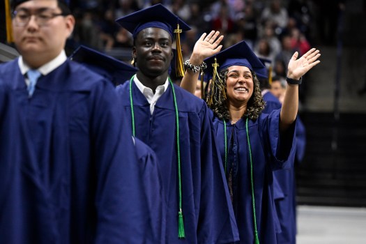 Kiera Jeffreys of Newtown, right, waves to her family during commencement at UConn in Storrs, Sunday, May 7, 2023.